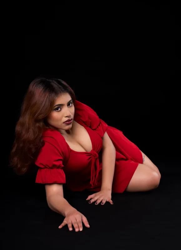 Studio fashion portrait in red against a black backdrop